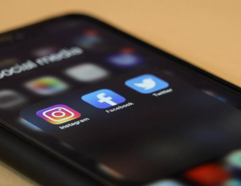 The face of a cell phone with icons of Instagram, Facebook and Twitter highlied