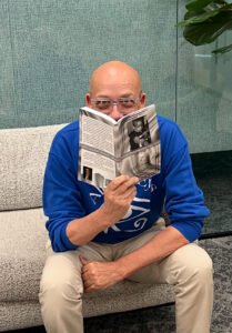 Todd in an office setting reading an advance copy of the book.
